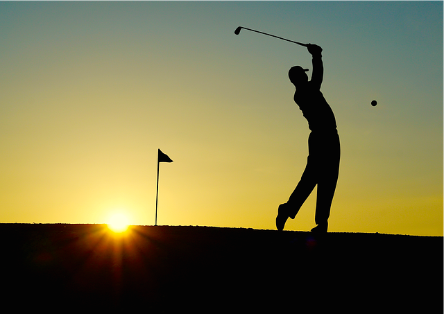 夕日の中ゴルフをしている男性