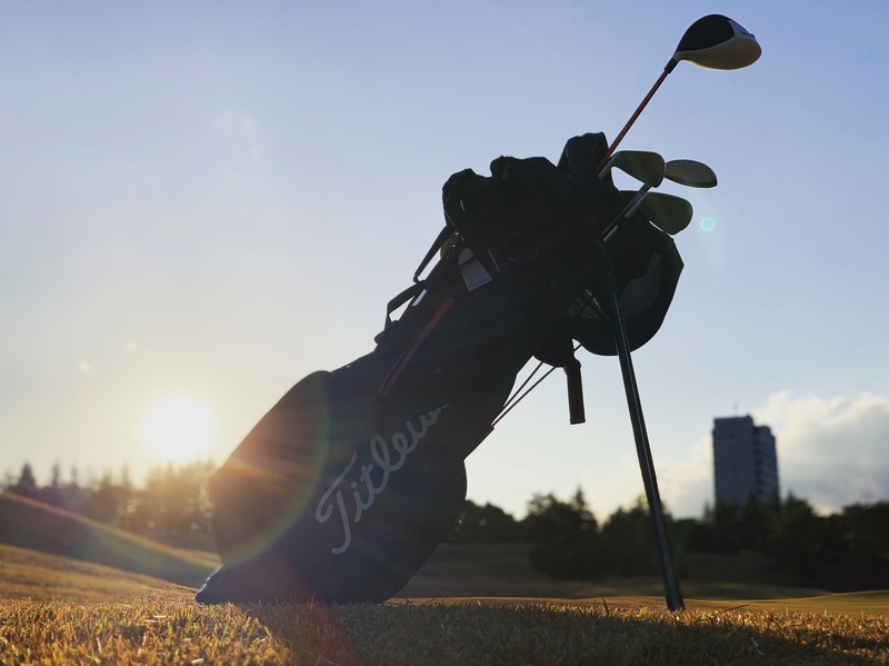 ゴルフセットが夕日と一緒に写っている