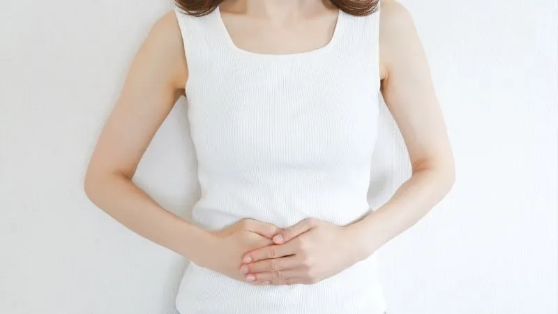 女性が胃にてをあてている