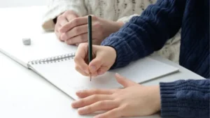 勉強してる子供と見守る母